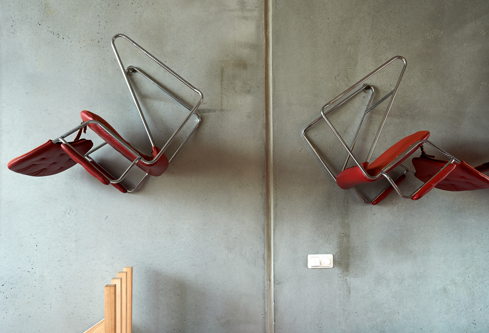 Kreativ upphängning av stolar i krokar på betongvägg