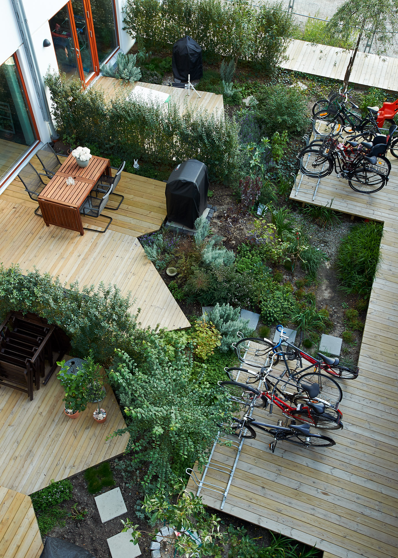 Innergård med uteplatser, trädeck, grönska och cykelparkering